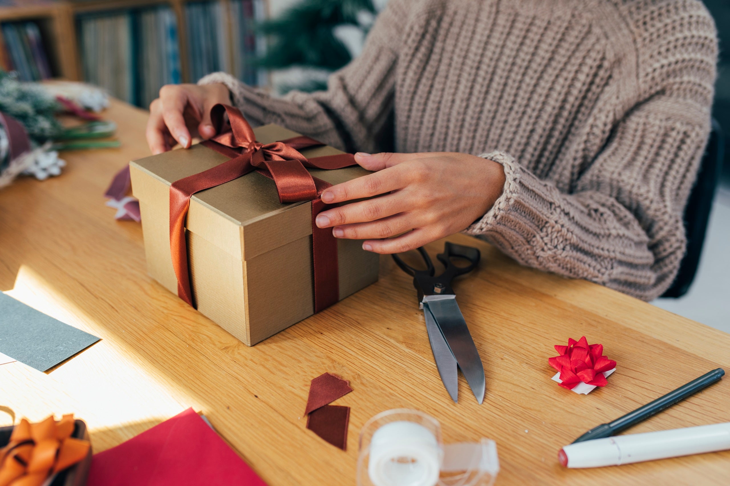 Getting Ready for Christmas: Hands of an Anonymous Woman Packing Christmas Presents for her Loved Ones