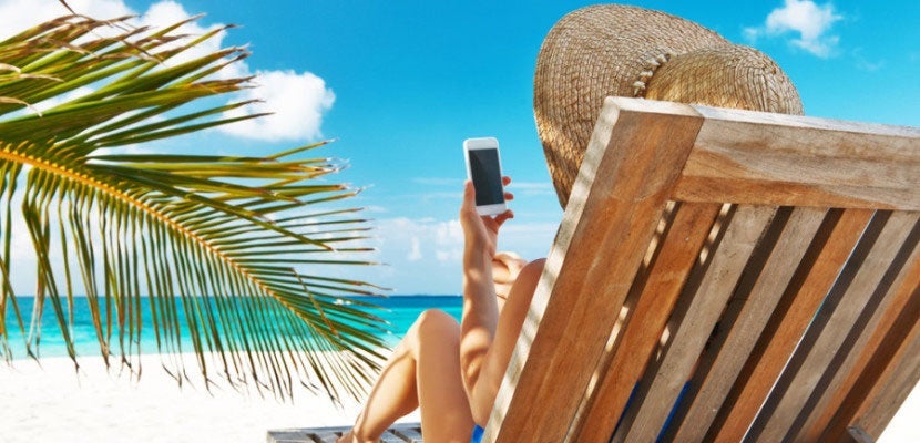 woman on the beach with her phone