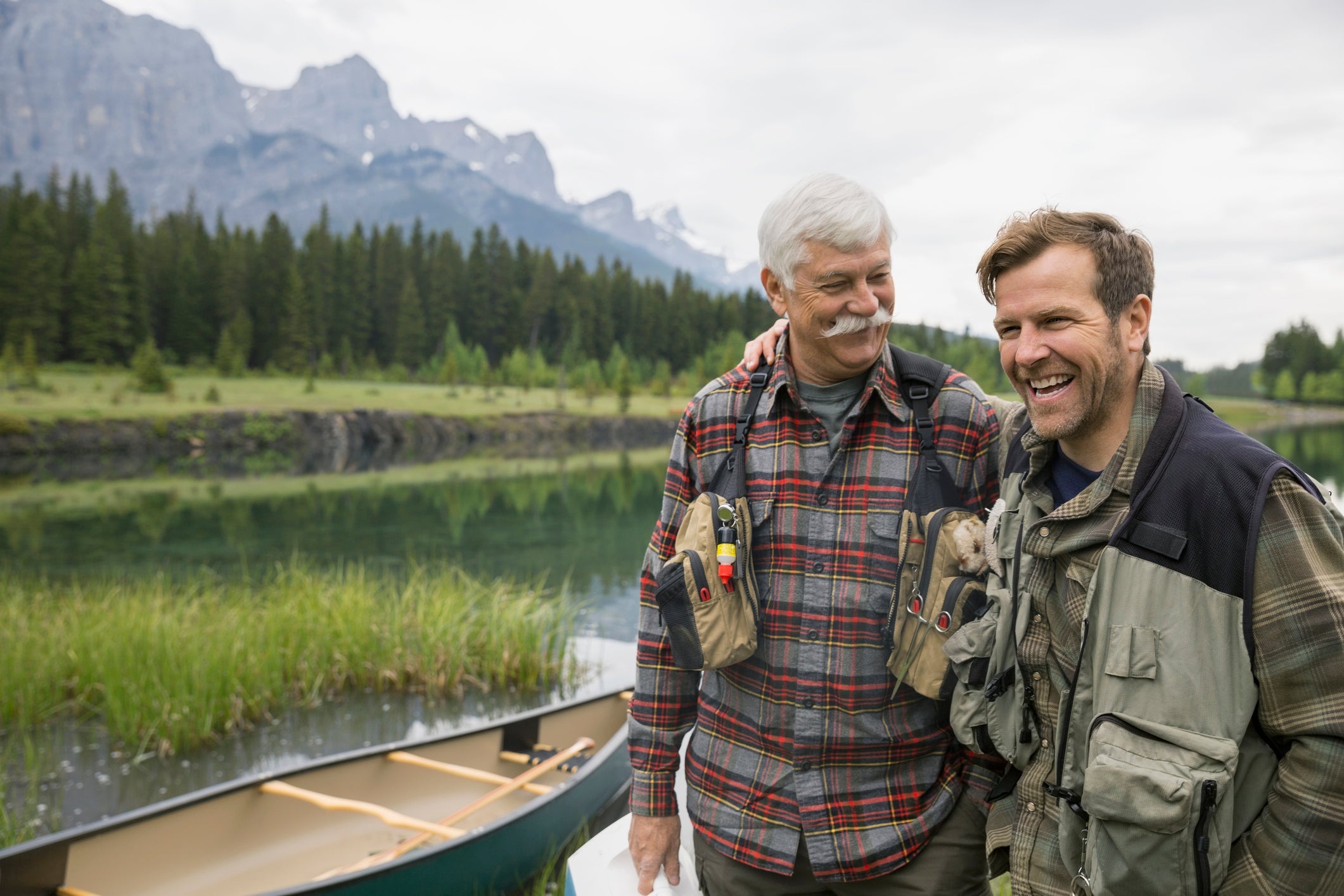 Father and son standing by still lake