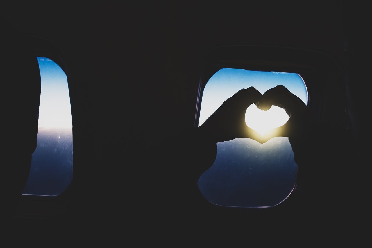 Hang making heart shape on the airplane window