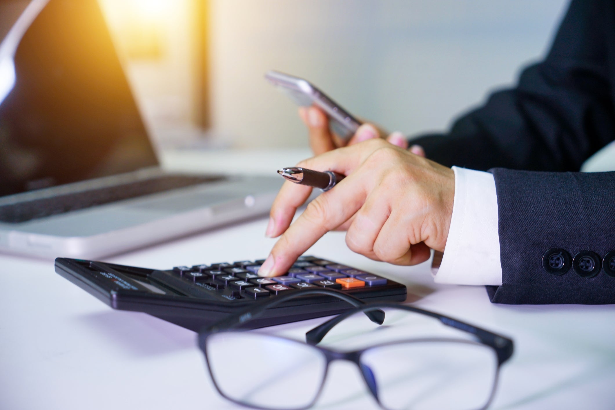 Close up of male accountant or banker making calculations. Savings, finances and economy concept