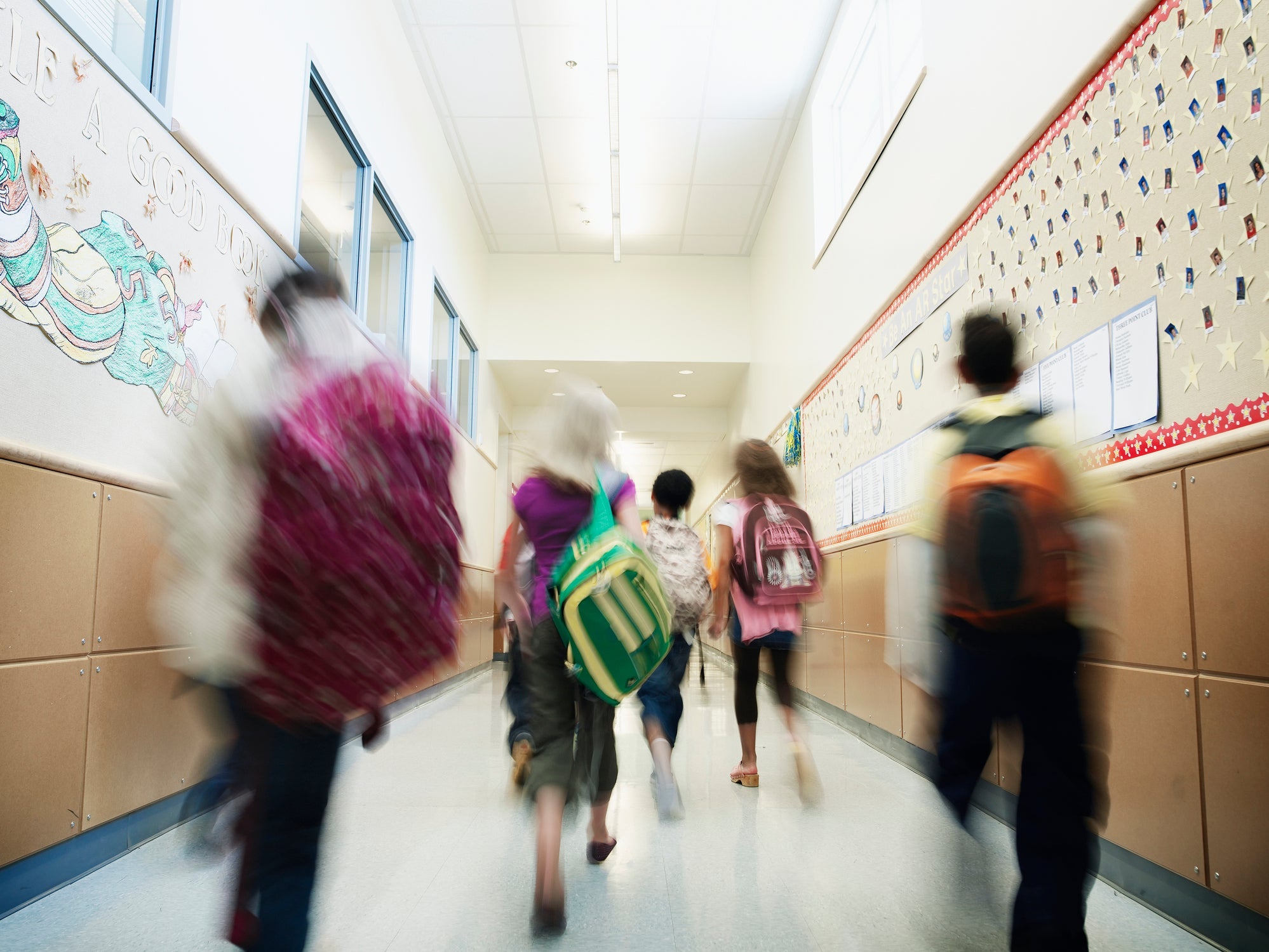 Young students walking down hallway of school