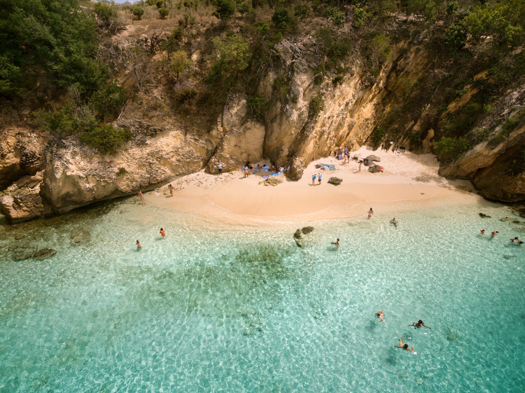 High angle view of people enjoying in sea against cliff