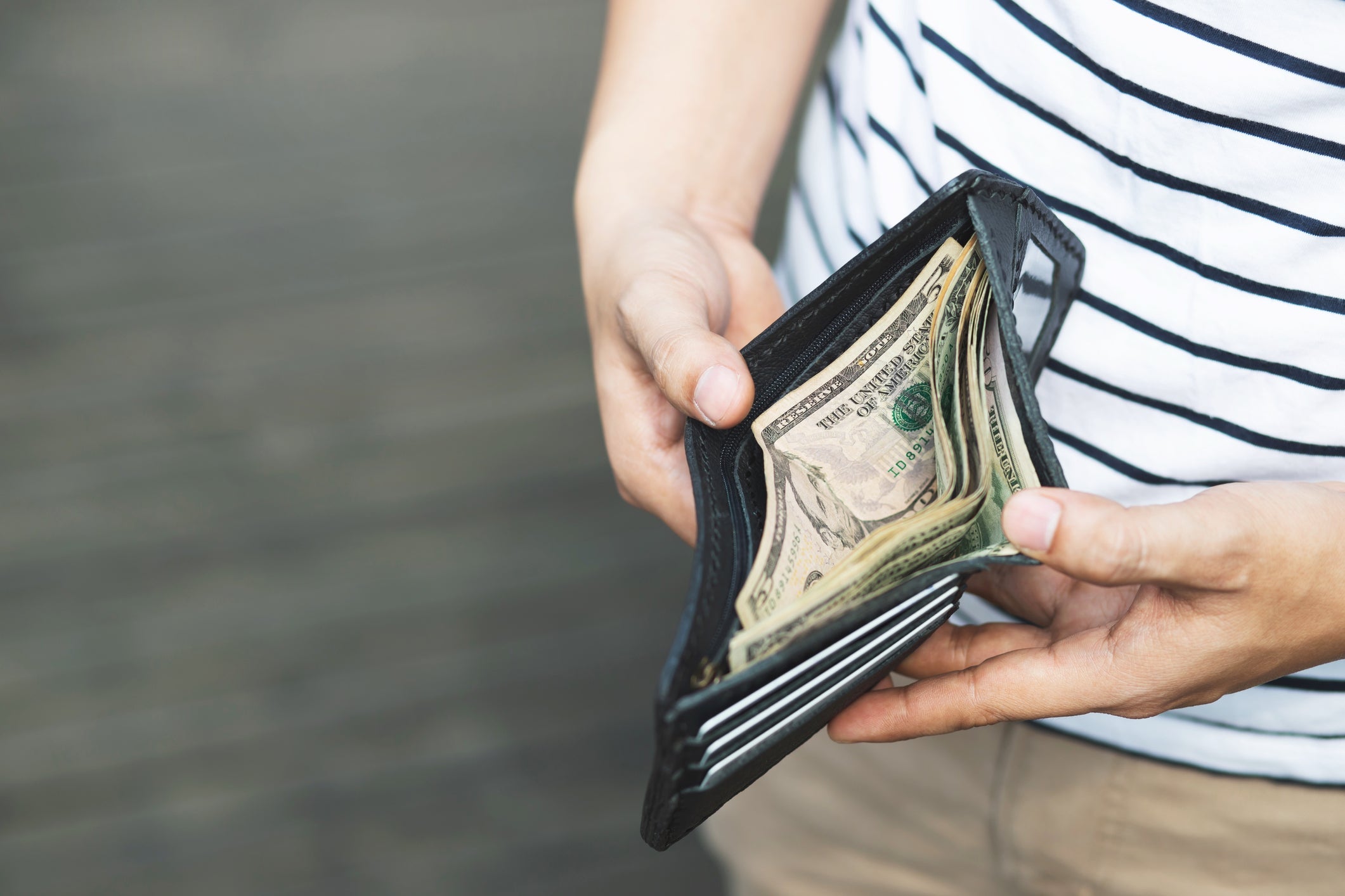 Midsection Of Man Holding Wallet With Paper Currency