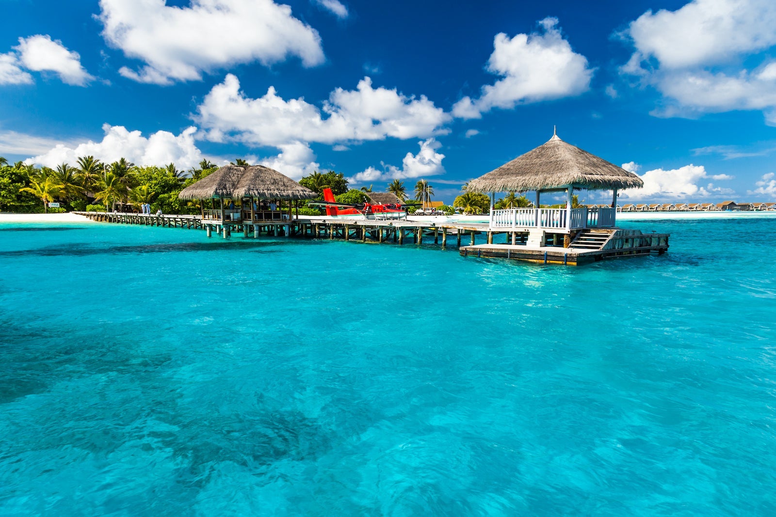 Perfect tropical island paradise beach Maldives. Long jetty and a traditional boat dhoni.