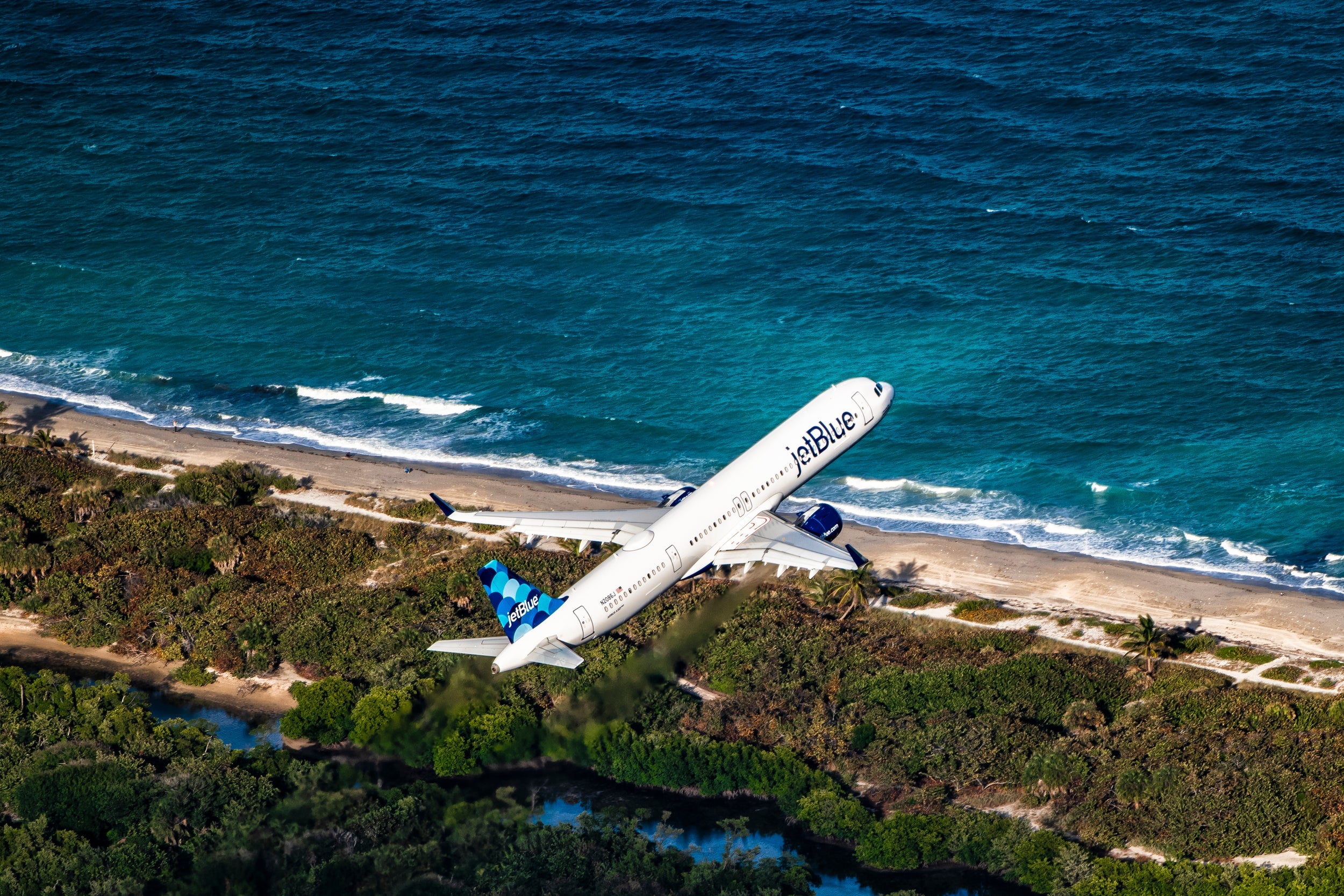 JetBlue plane flying over the ocean