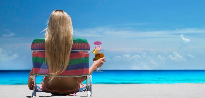 Woman relaxing in lawn chair on beach