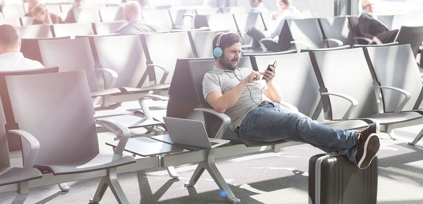 Man with headphones waiting at airport departure lounge