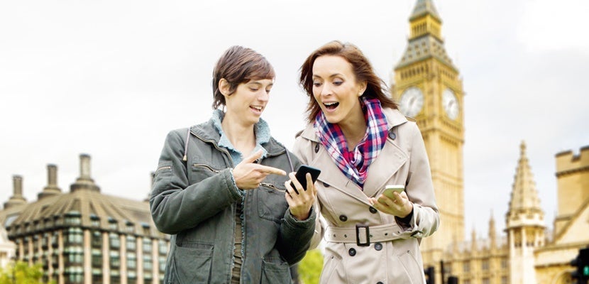 Two female tourists use their phones to navigate in London