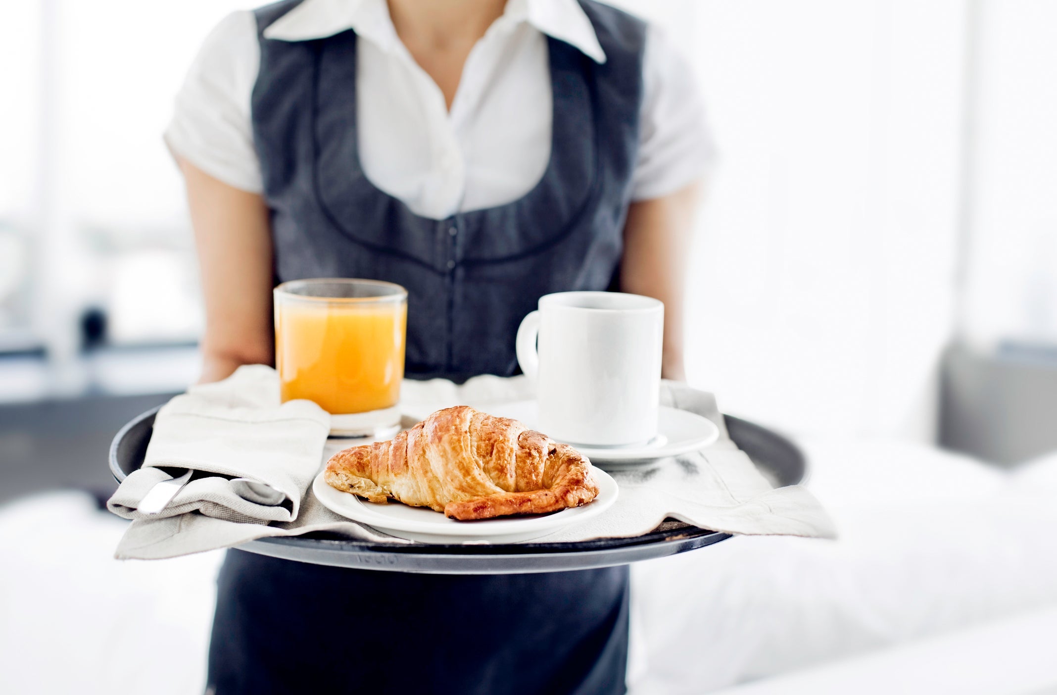 Room service hotel staff carries breakfast tray