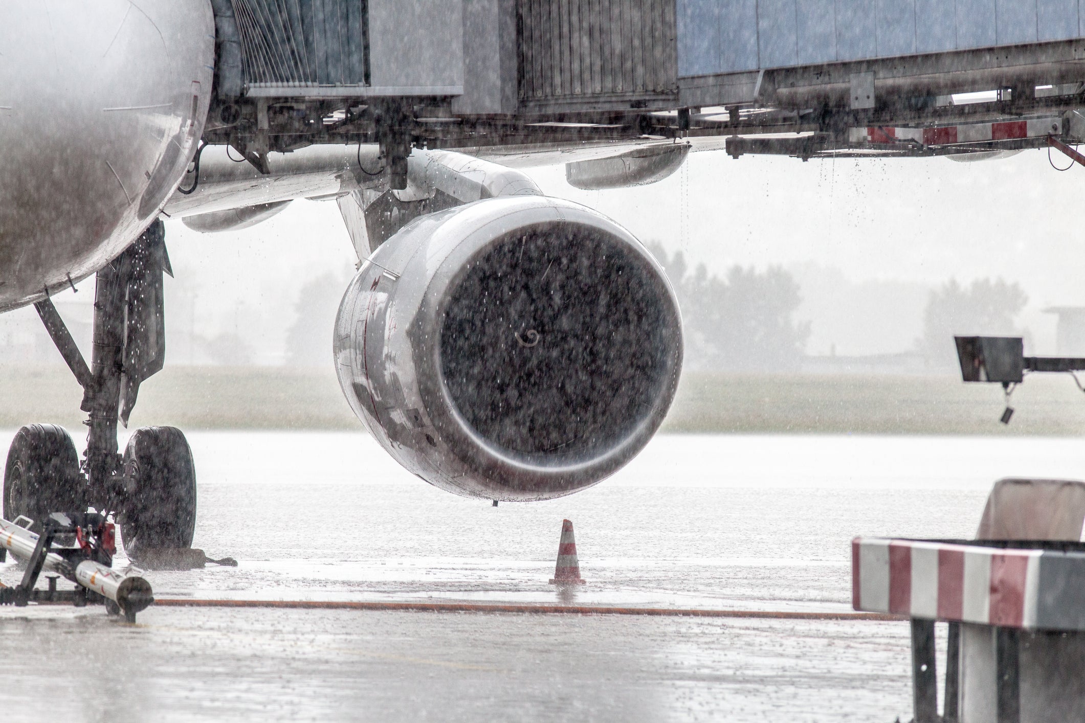 Cropped Image Of Airplane On Runway During Rainfall