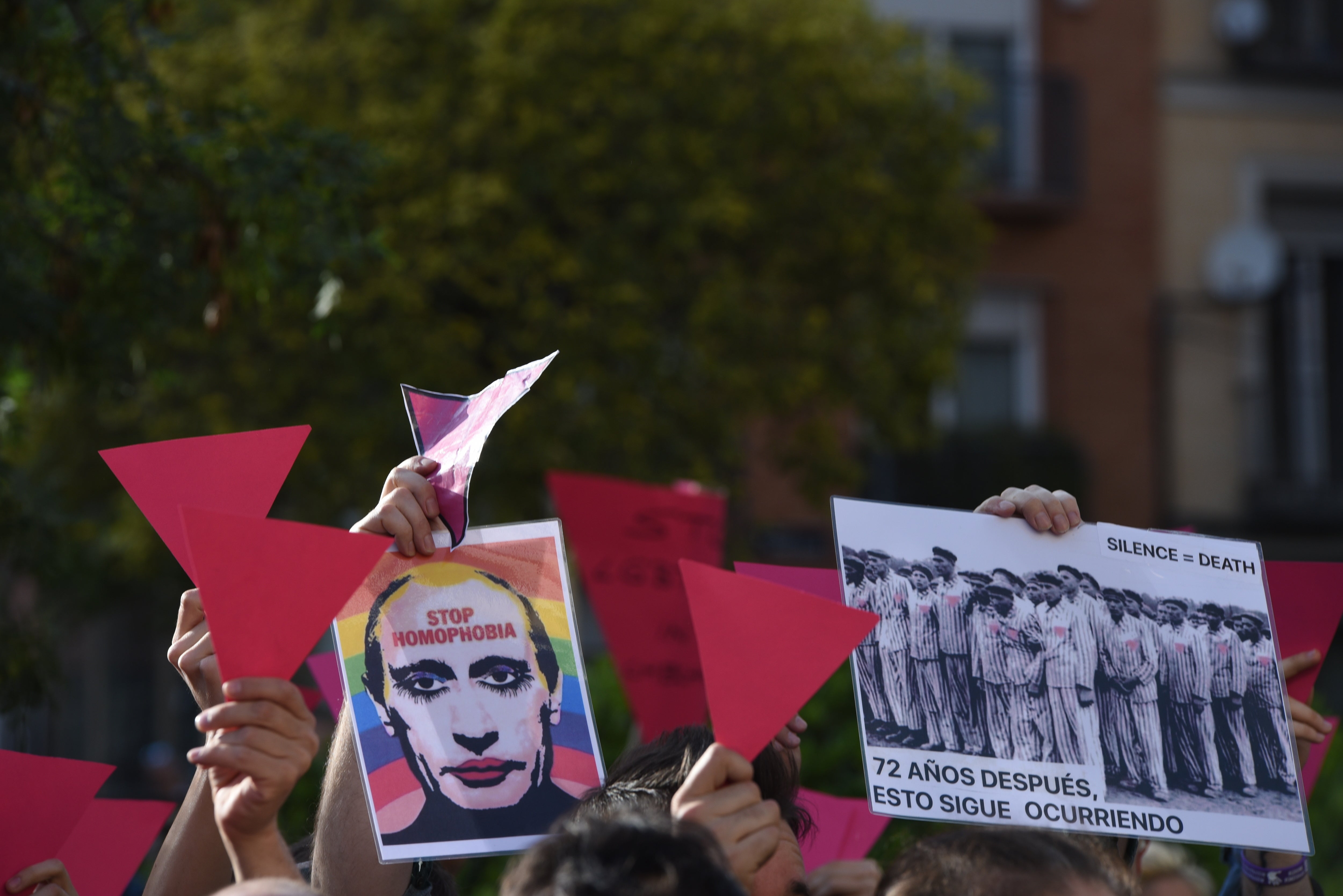 People show pink cards and a picture of Vladimir Putin as