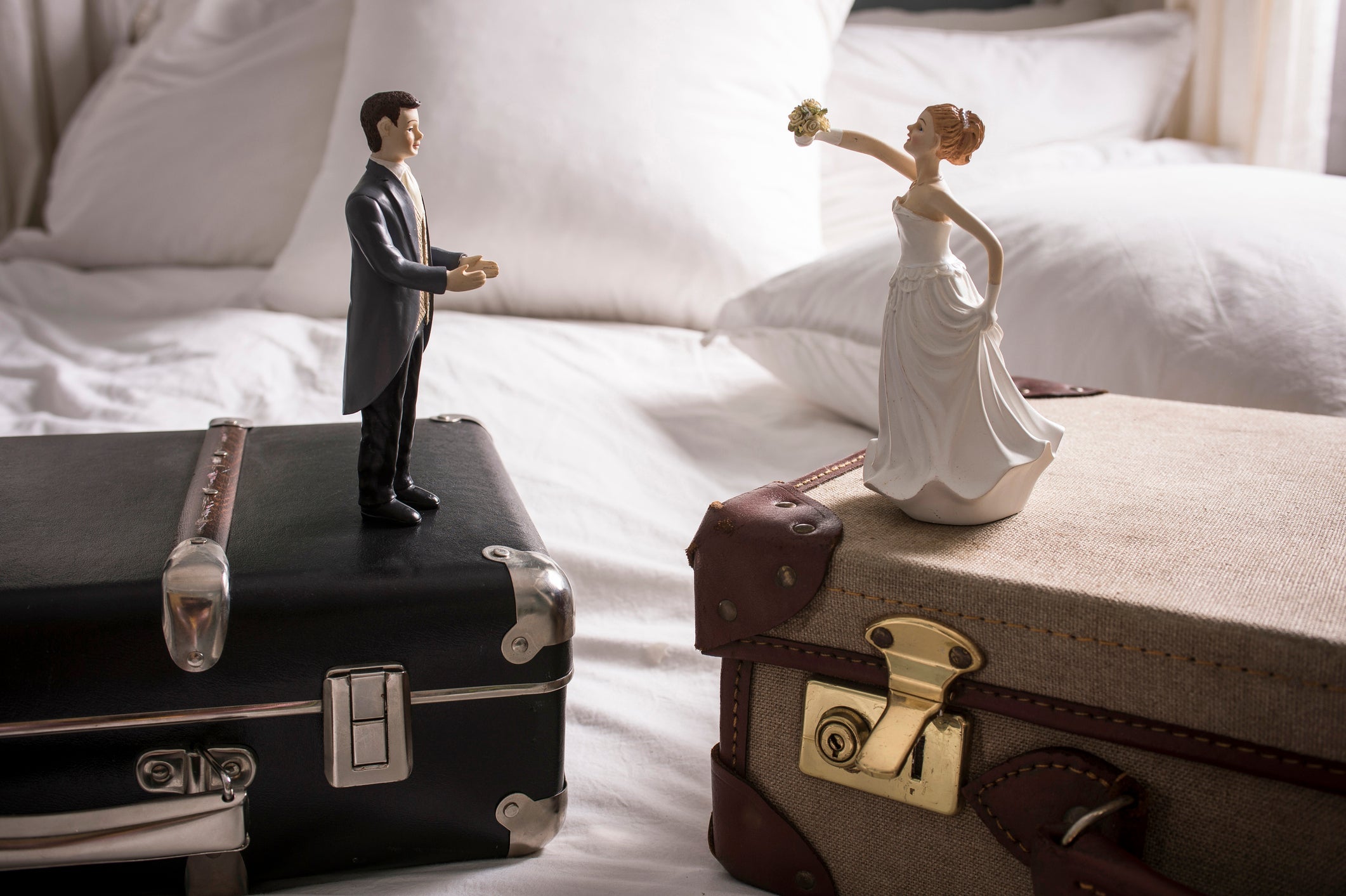 Wedding figurines on separate suitcases