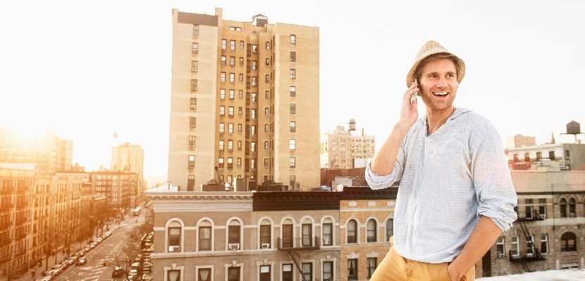 Caucasian man talking on cell phone on urban rooftop