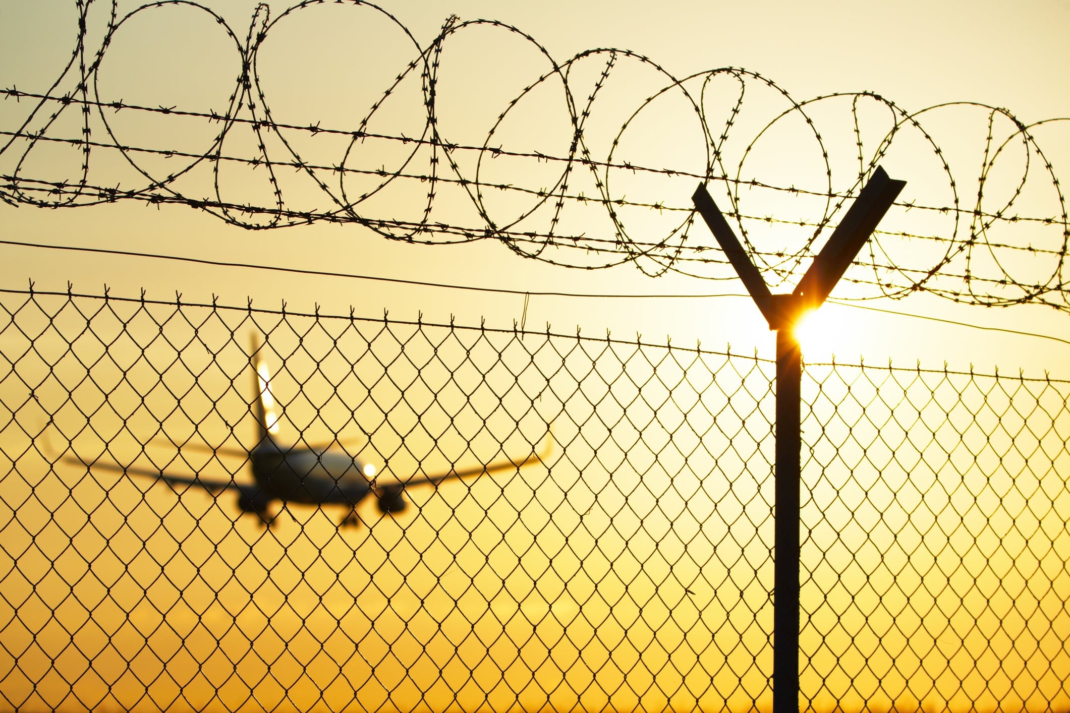 Airport behind guard fence in sunset