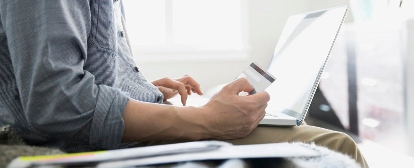 Man shopping online with credit card and laptop