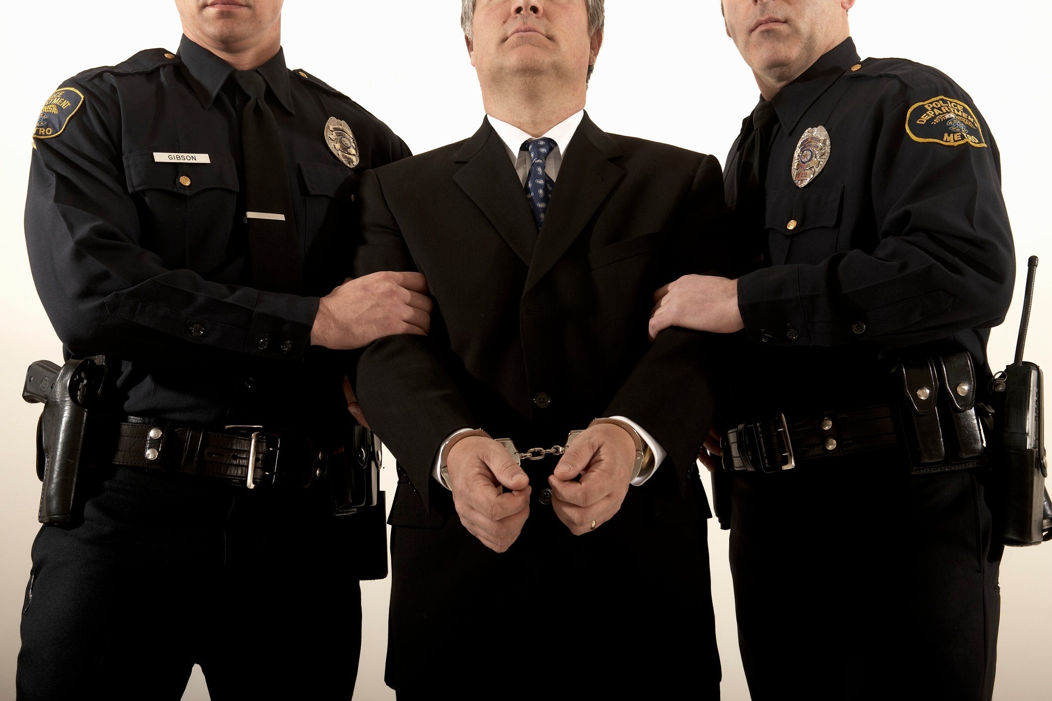 Male police officers arresting businessman