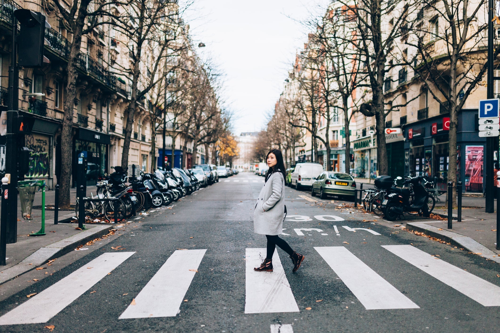 Asian woman crossing zebra in Paris
