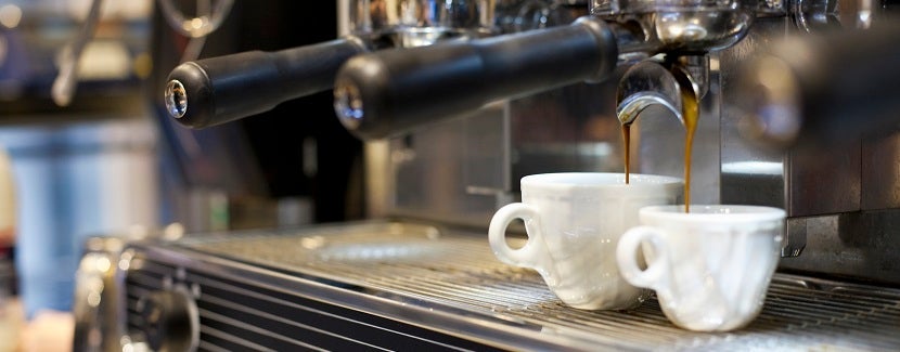 espresso machine pouring coffee into cups