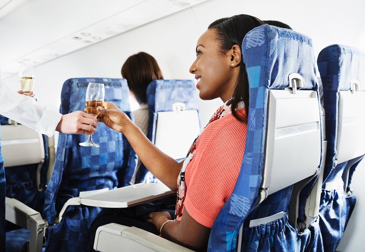 woman-champagne-plane-credit-getty