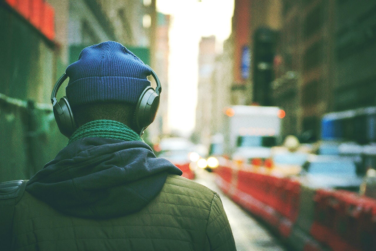 Rear View Of Man Listening To Music In Street