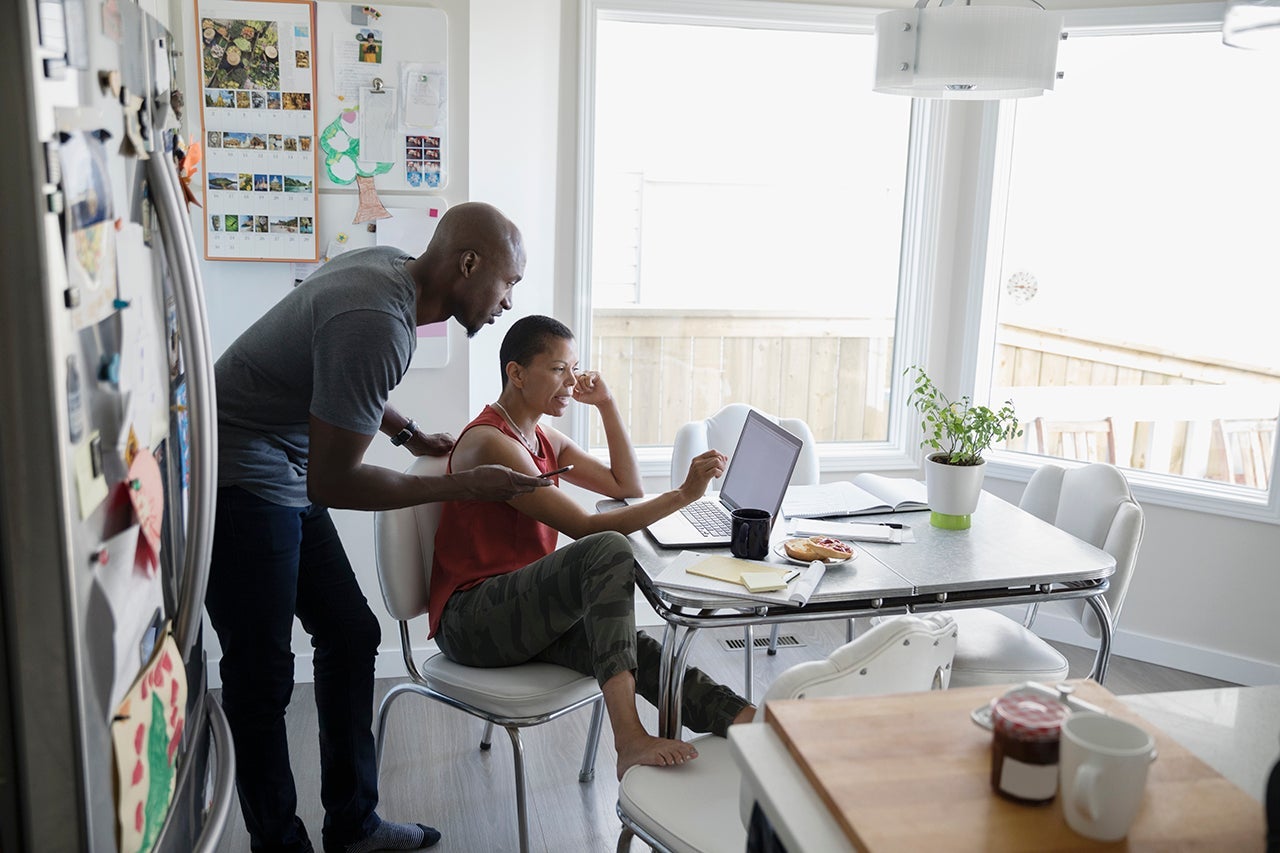 Mature couple using laptop at kitchen table