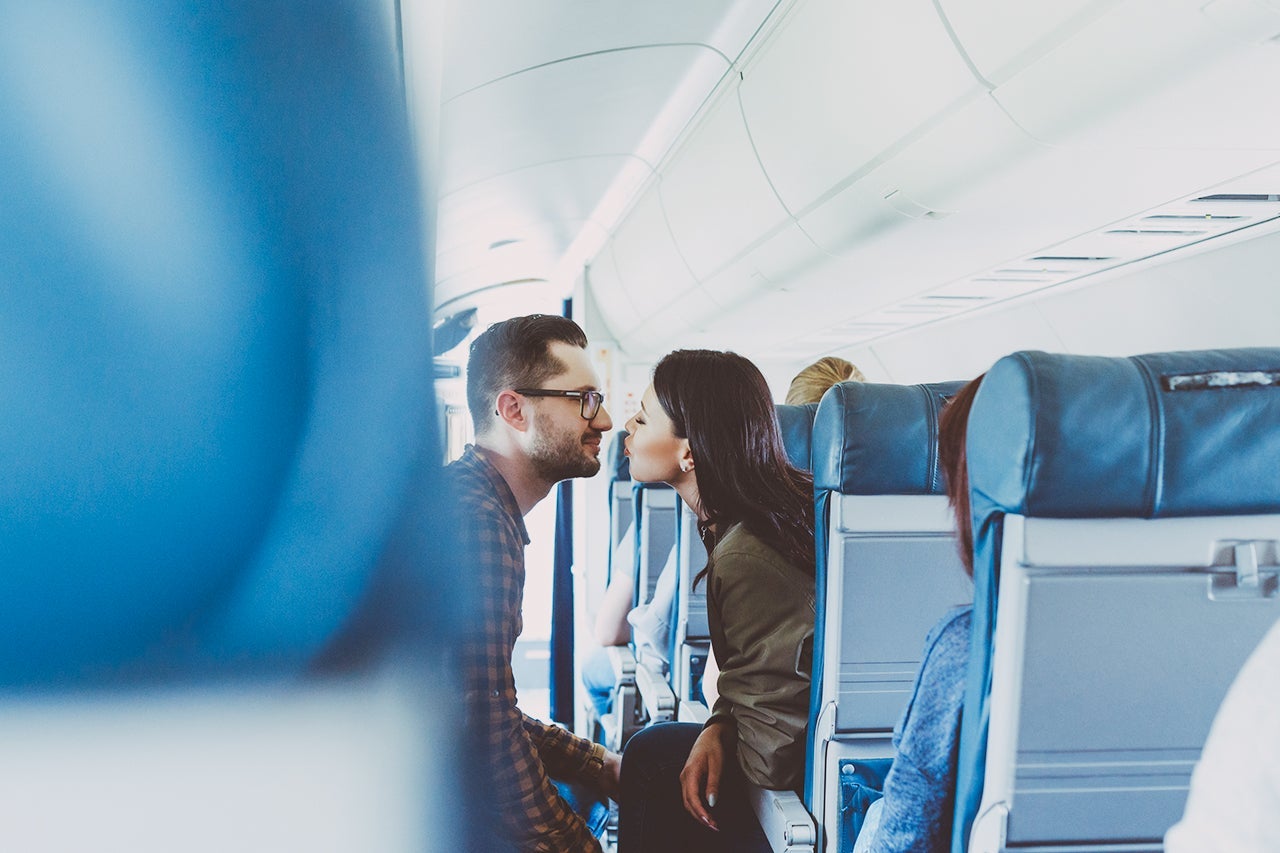 Loving young couple about to kiss in flight