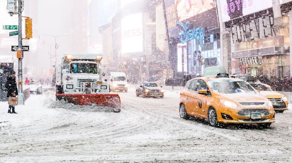 A snow clearing truck seen with taxis during snow storm in