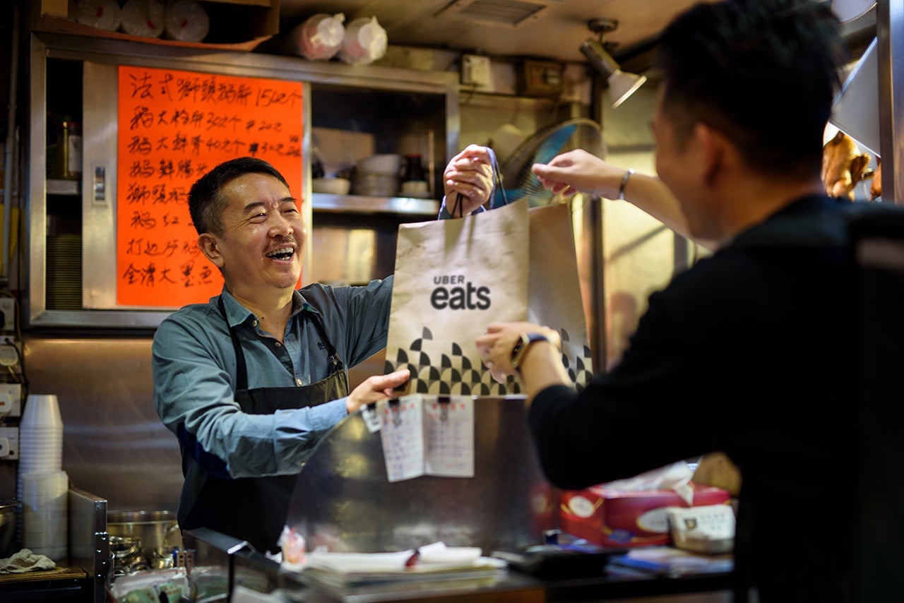 Chef giving food bag to a delivery man