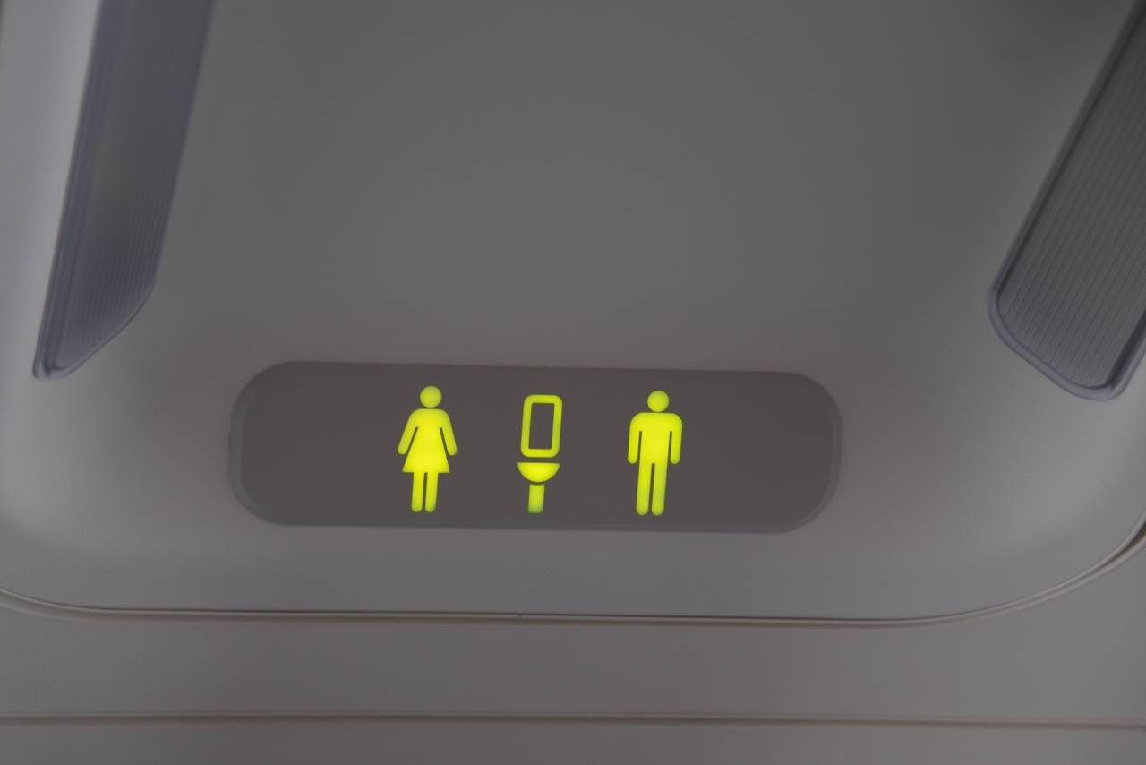Lit on signal of bathrooms for men and women on a plane