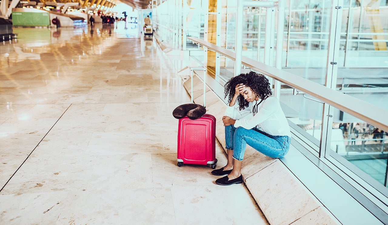 Woman sad and unhappy at the airport with flight canceled