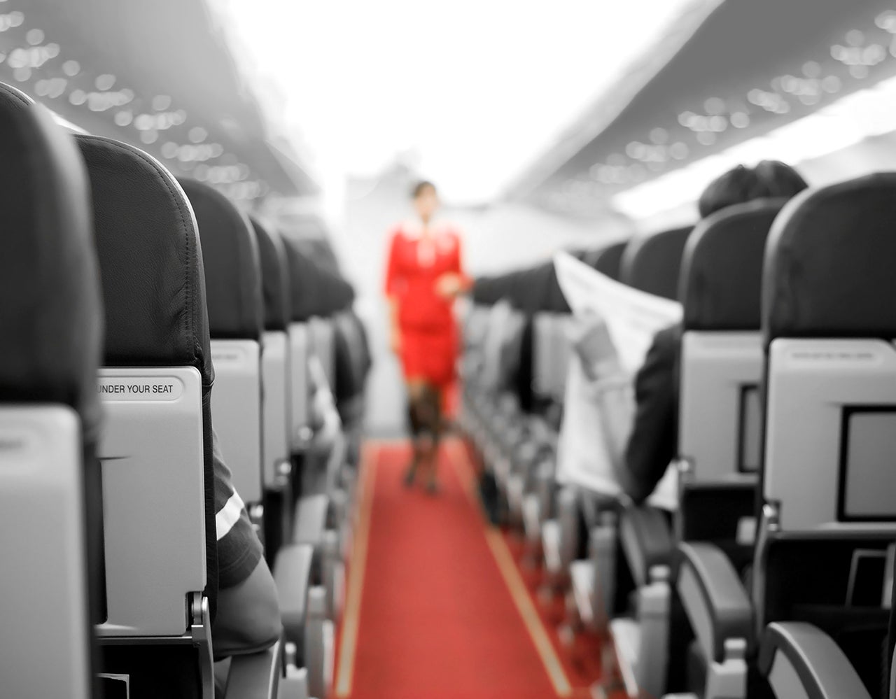 Interior of an airplane with cabin crew in the background