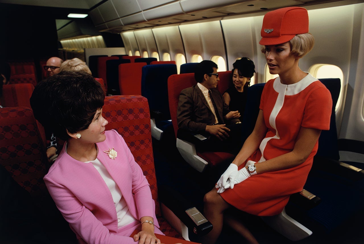 Flight Attendant With Passengers