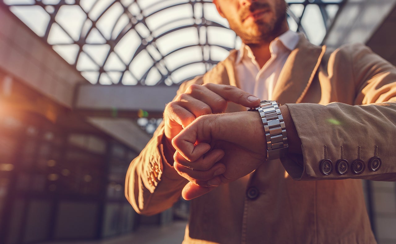 Close up of a man checking the time on wristwatch.
