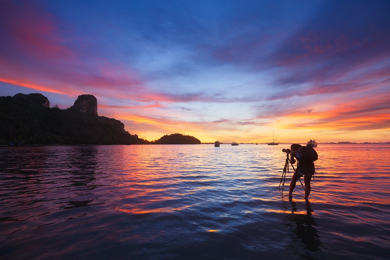 Photographer taking photo of sunrise at East Railay Bay Beach - Krabi, Thailand