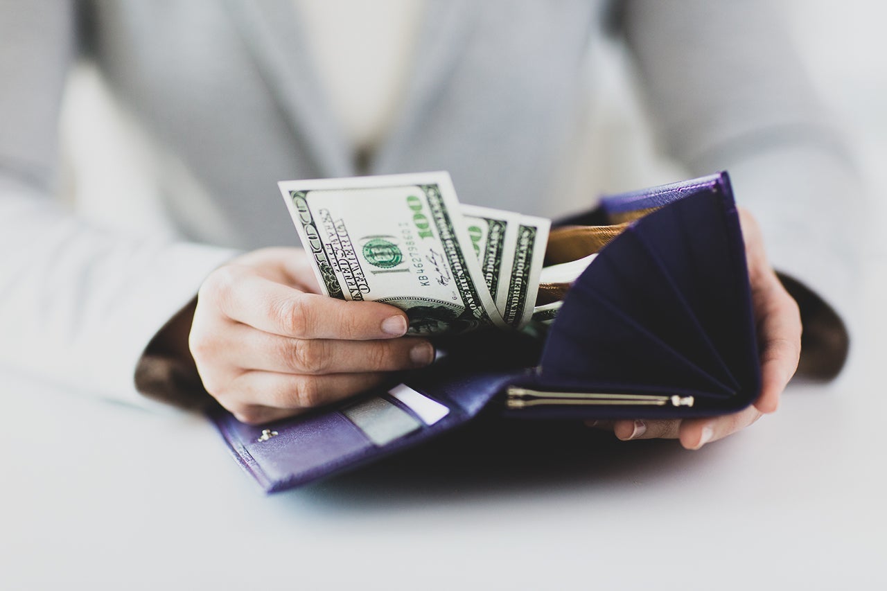 close up of woman hands with wallet and money