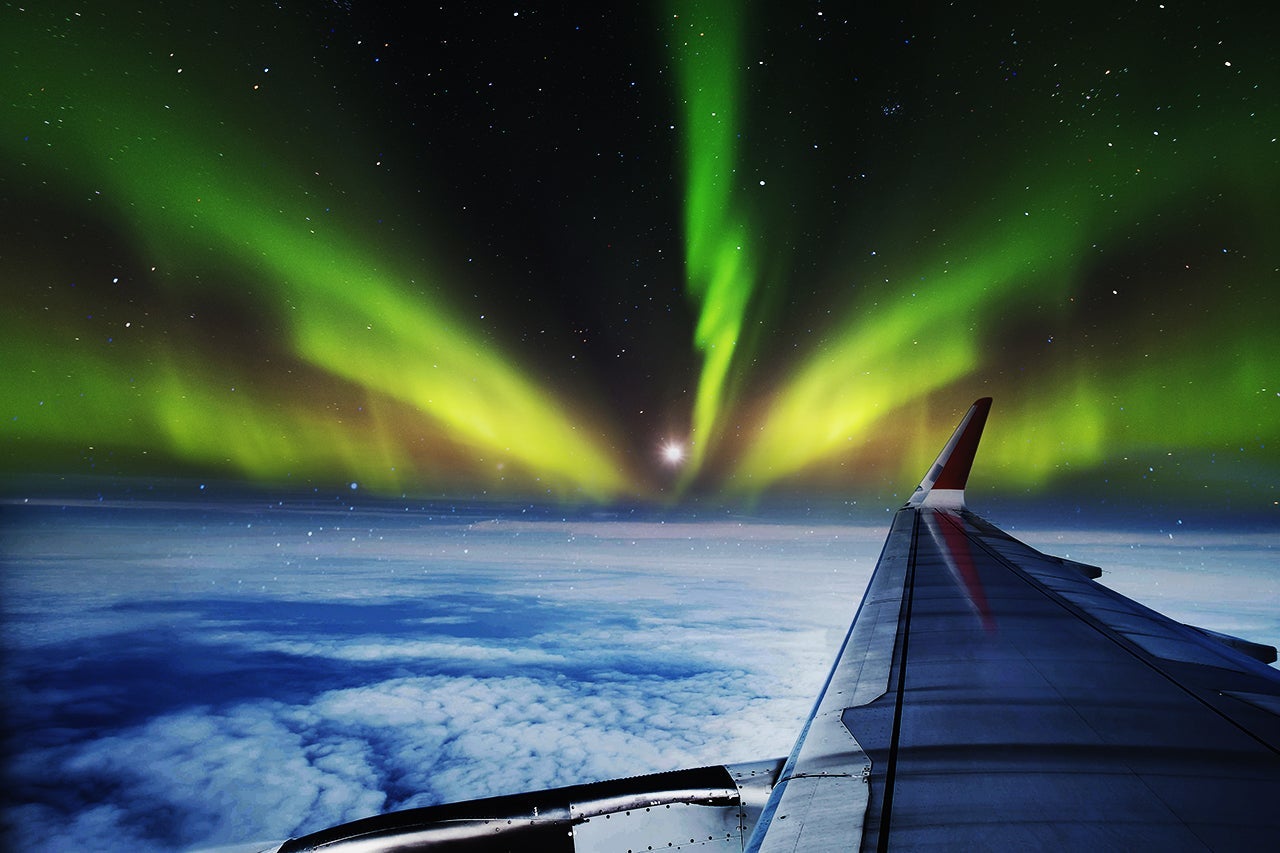 Aerial view of Northern Lights (Aurora Borealis) from window of an flying airplane