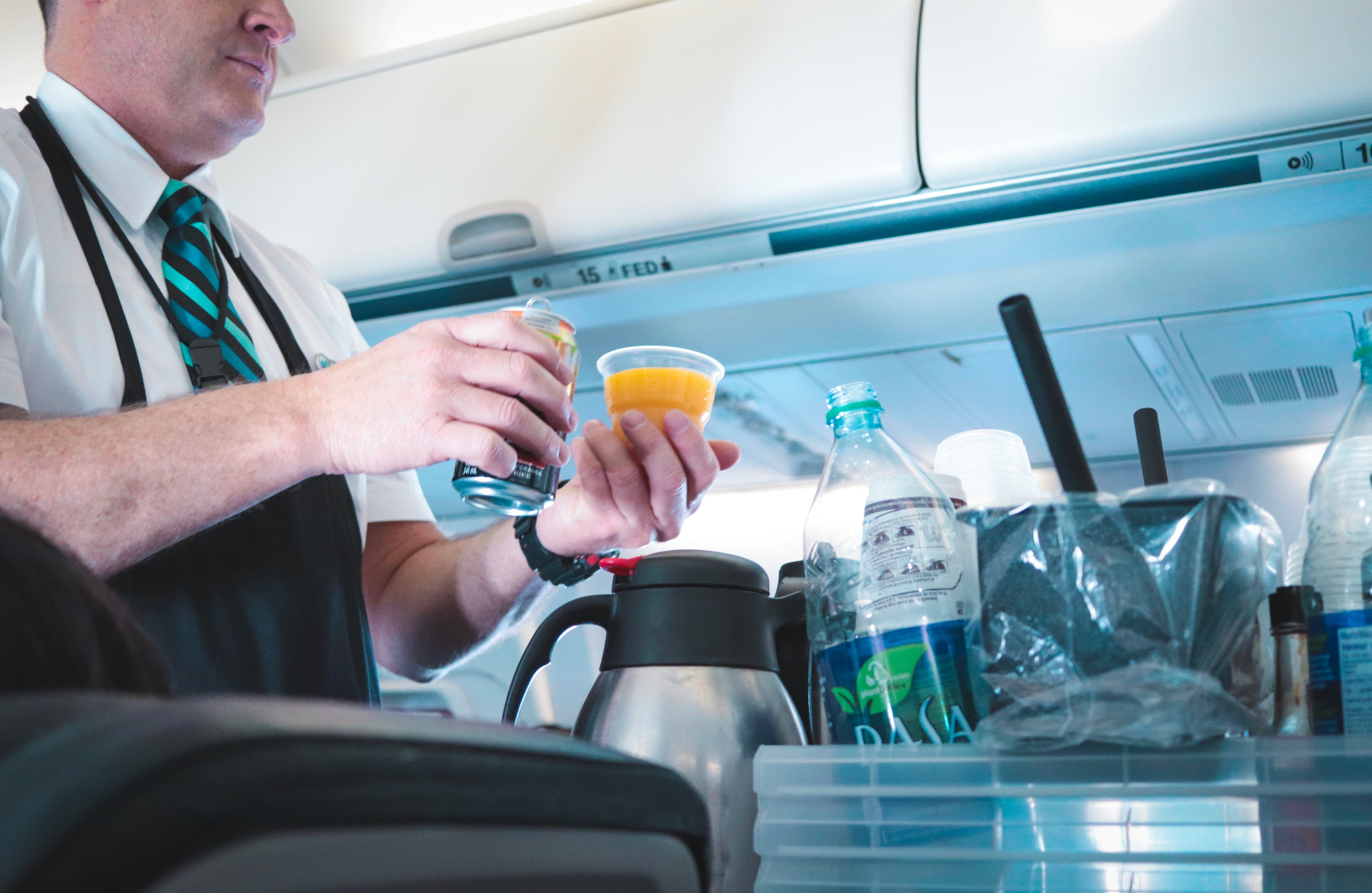 a-flight-attendant-pouring-drinks-for-passengers_t20_8lG8OB