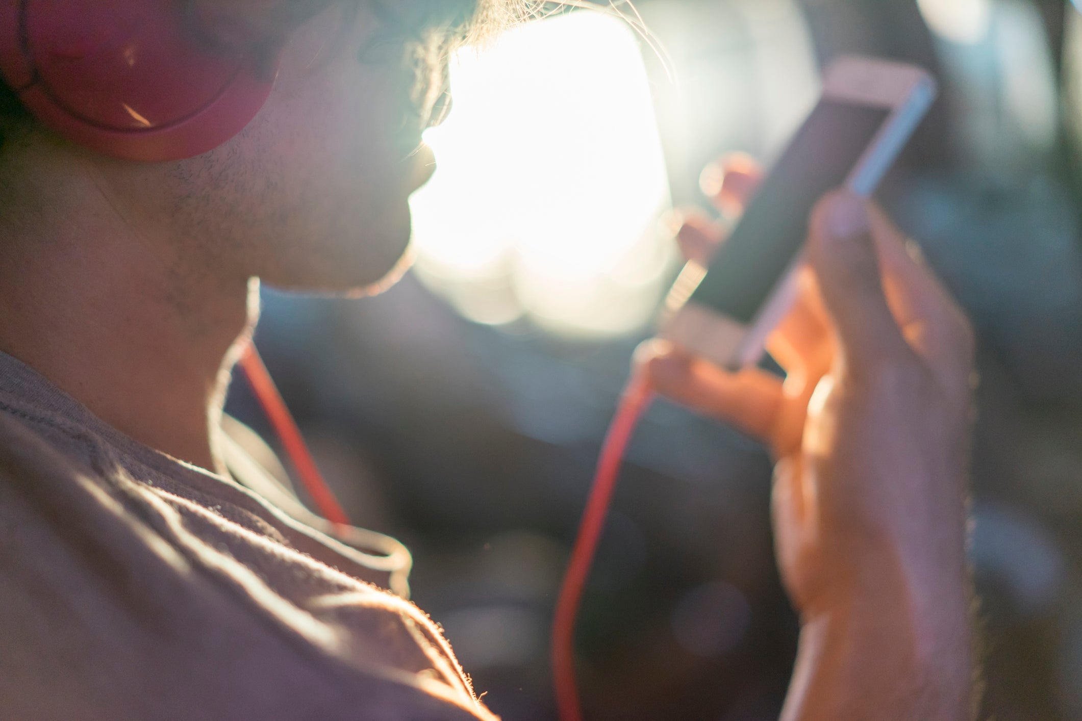 Young man in plane with cell phone and headphones