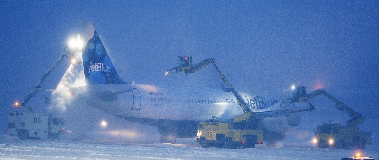 A JetBlue plane gets de-iced prior to taking off at the Portland International Jetport in Portland o