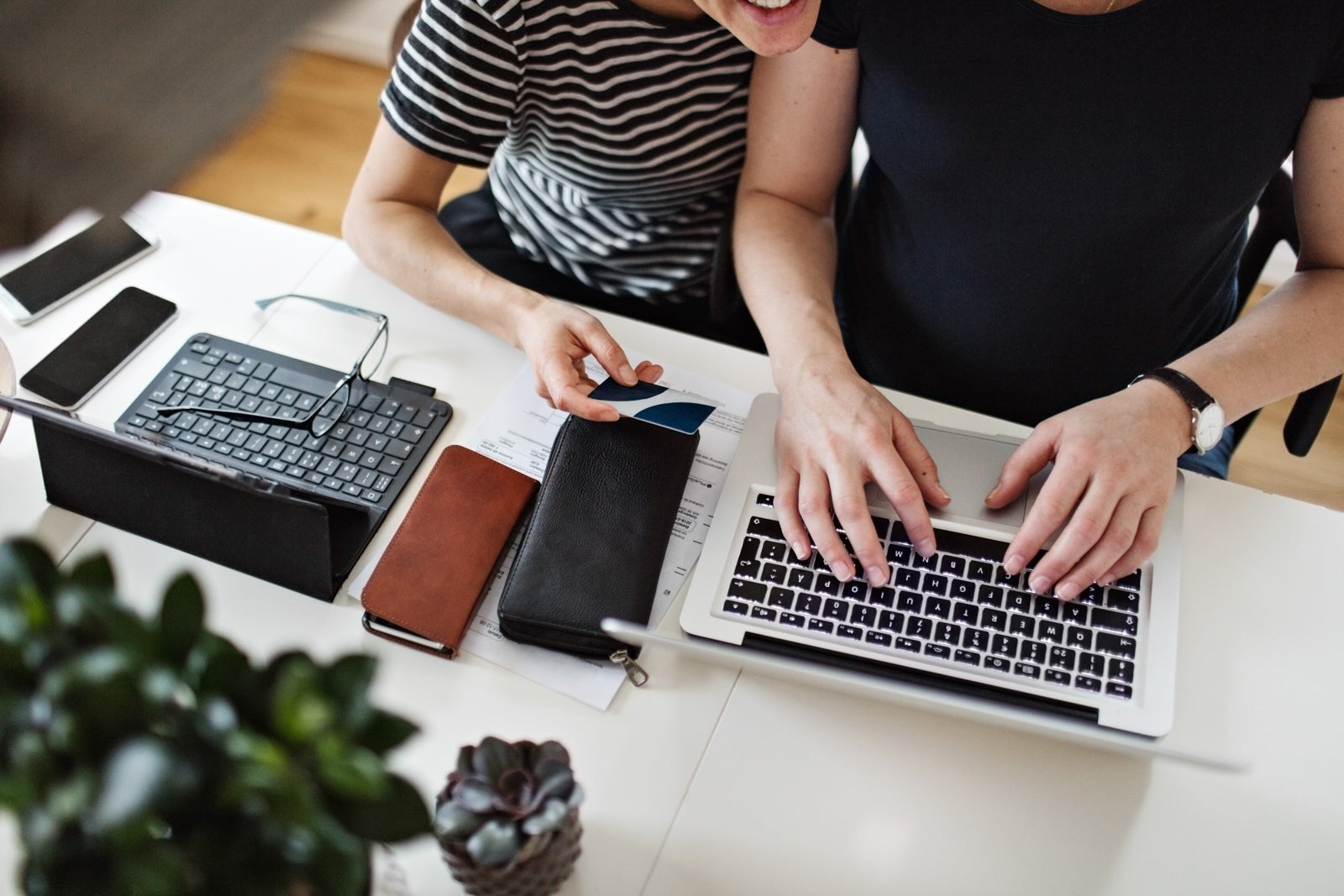 High angle view of lesbian couple shopping online through credit card on laptop at table
