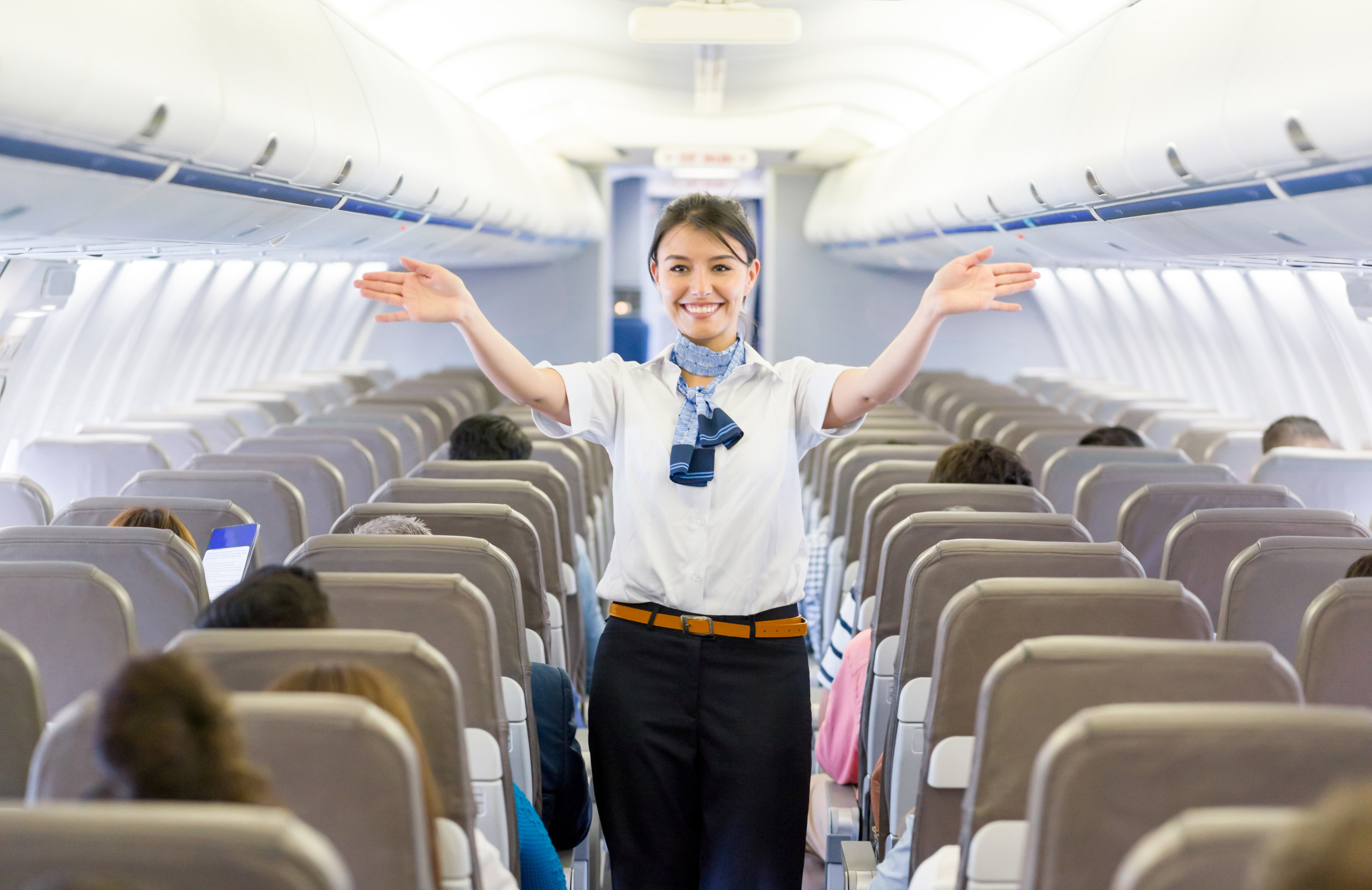 Flight attendant showing the emergency exit in an airplane