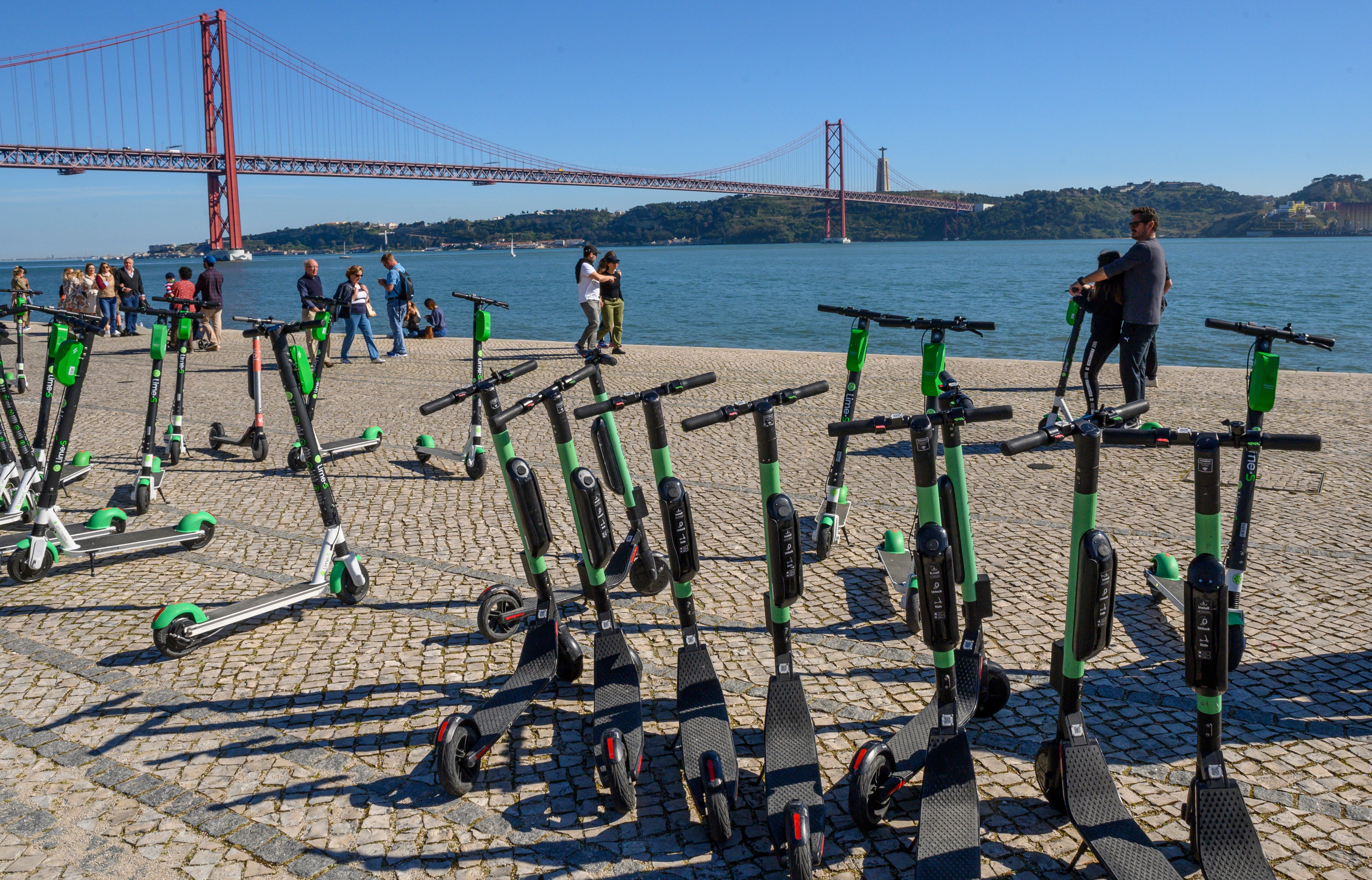 Tourists and locals ride e-scooters in Lisbon"n