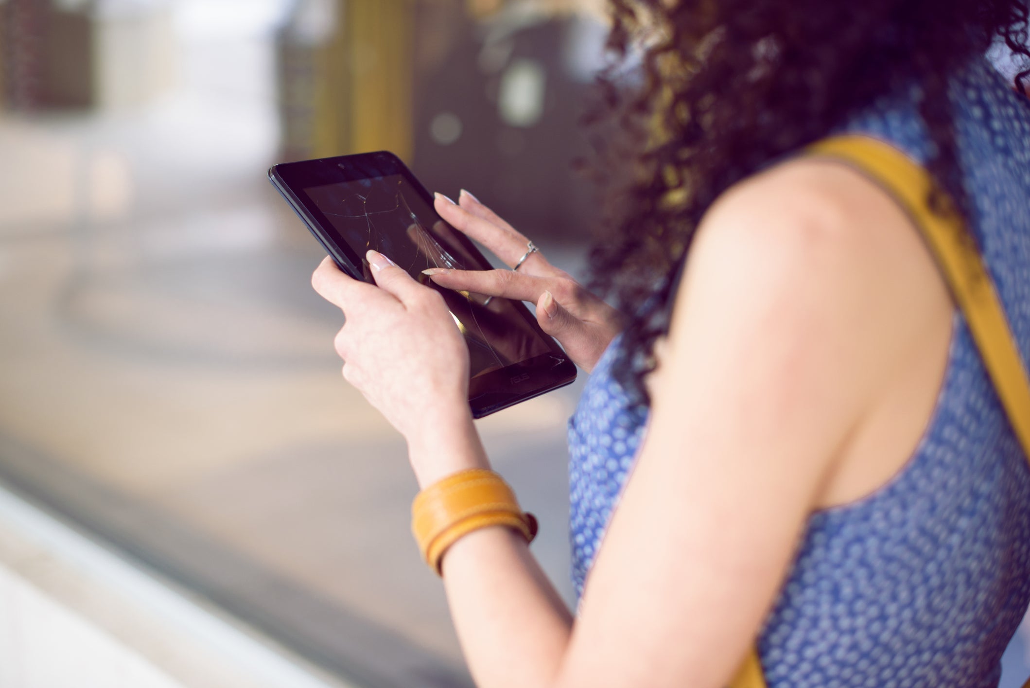 Young woman holding digital tablet with broken screen