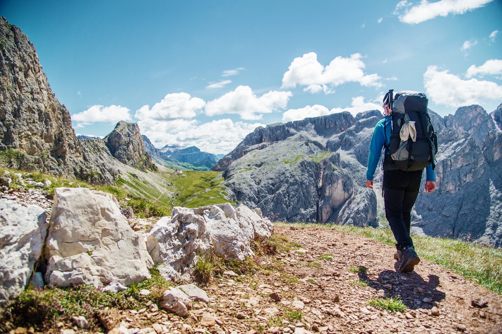 Male hiker with rucksack walking on pathway in the Alps