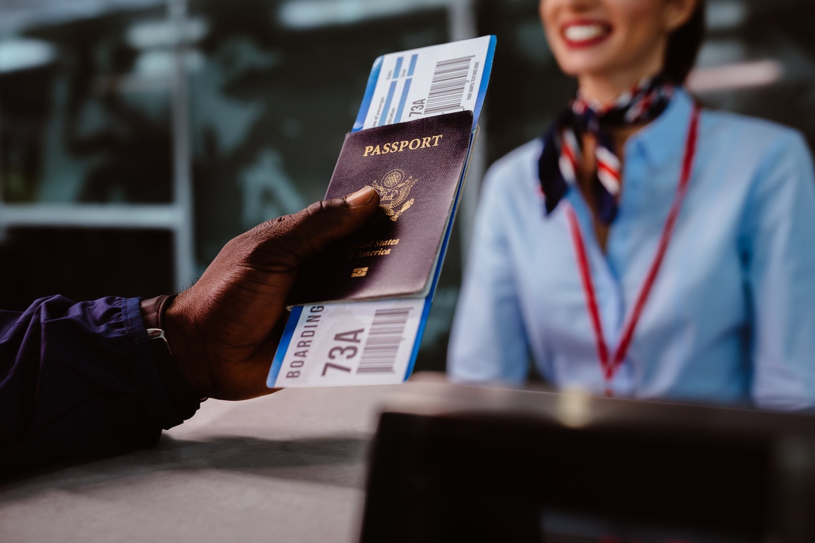 Man holding passport and boarding pass at airline check-in counter