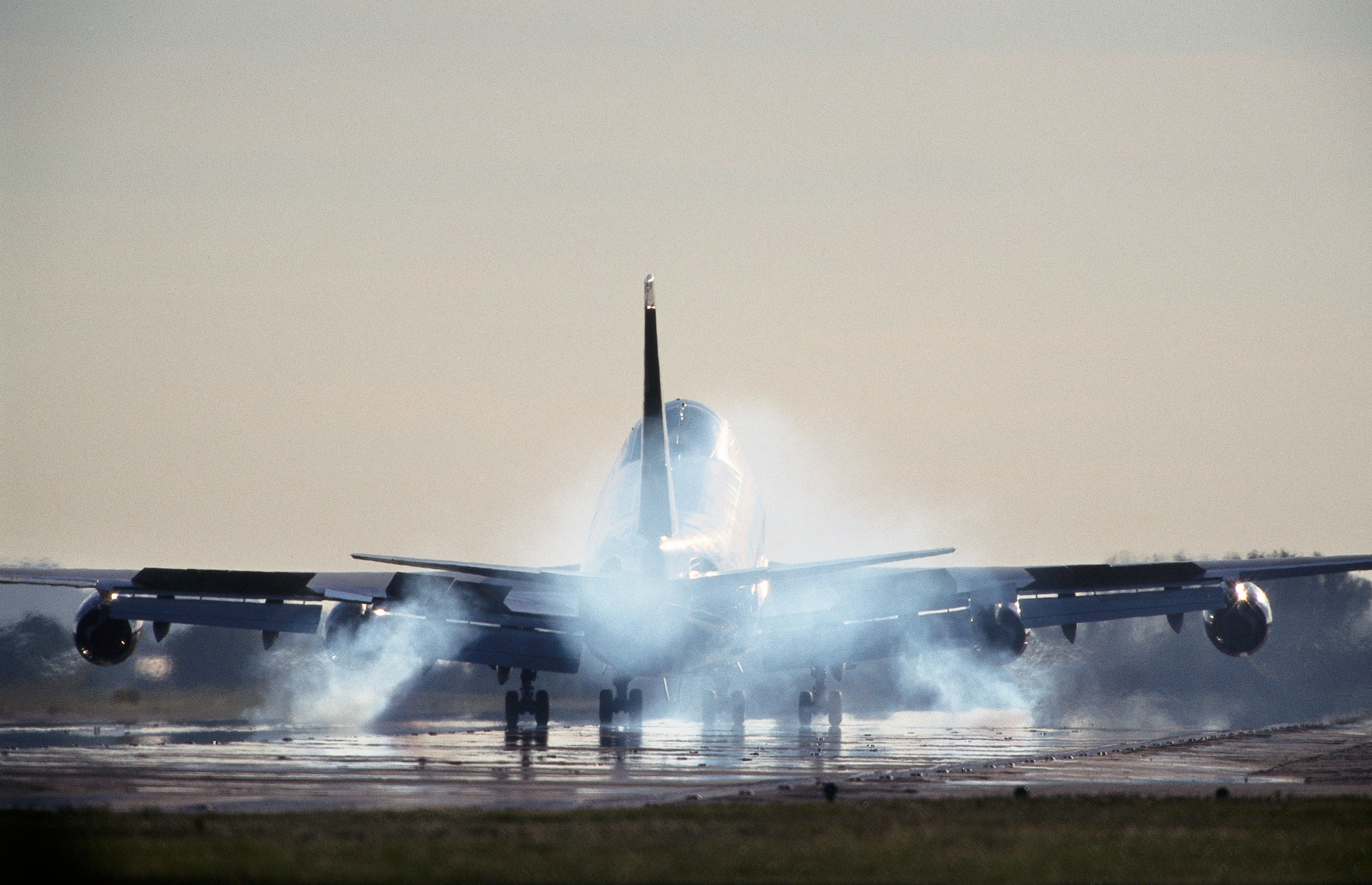 Boeing 747-400 with smoking tyres at touchdown landing on the runway