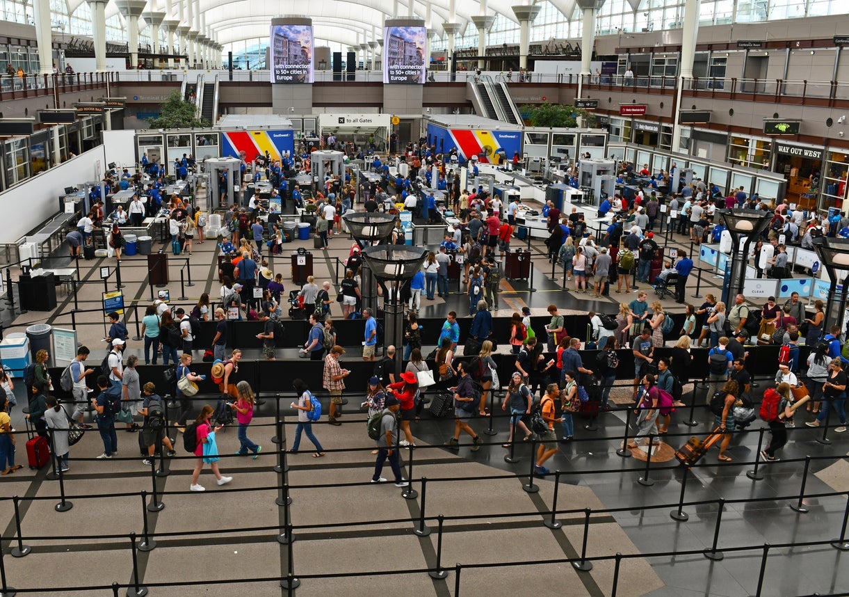 Crowds of travelers in long queue at TSA Security Check at Denver International Airport over summer holiday weekend.