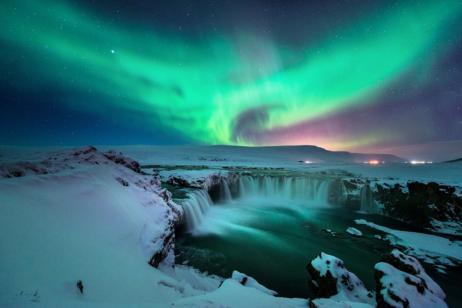 A stunning aurora shape like phoenix bird appears above the landscape of Godafoss water fall in winter Iceland