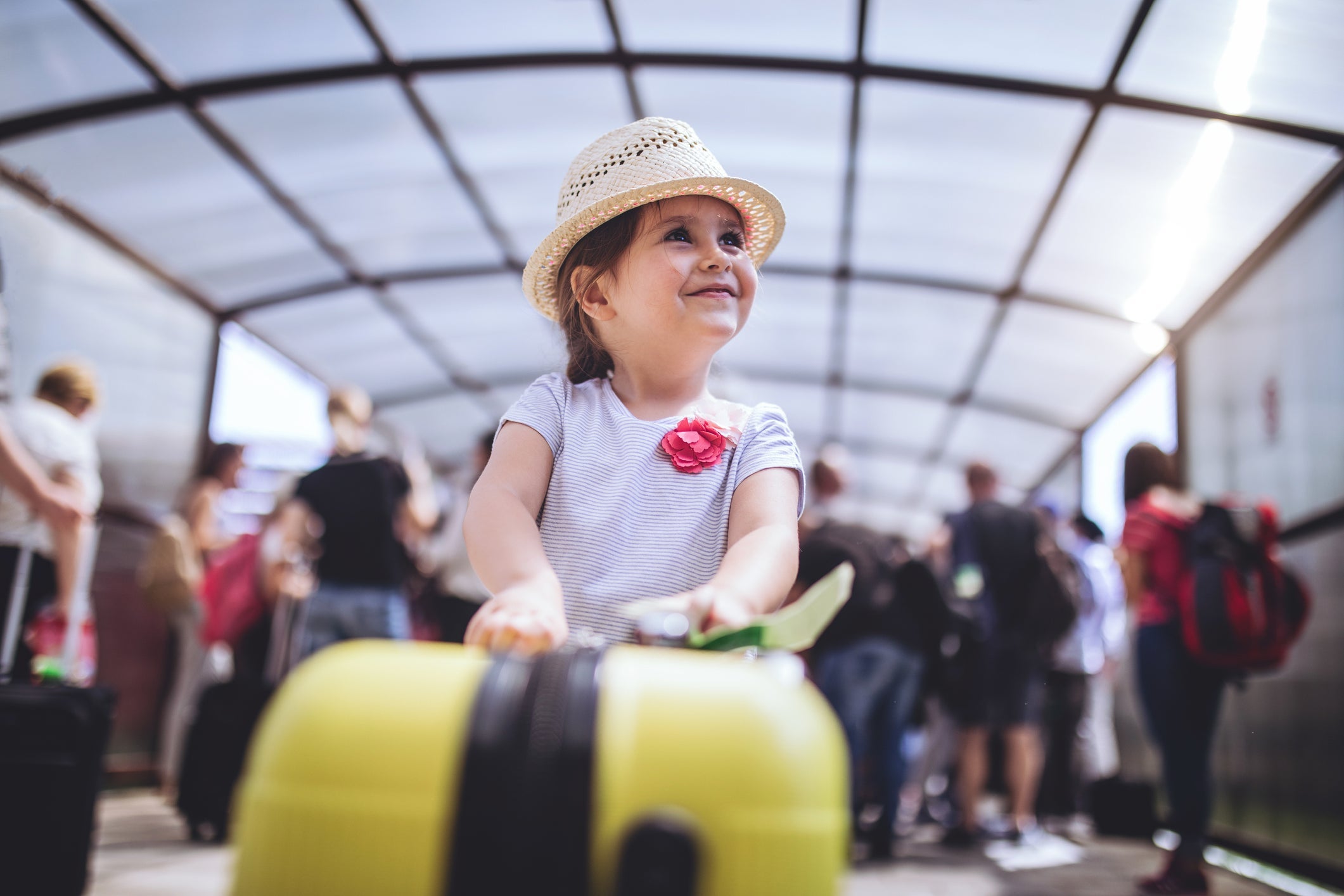 Cheerful and excited toddler with her coffer on a airport